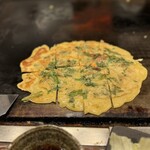 お好み焼屋みっちゃん - 「春菊と豚肉のチヂミ」 一口目は豚肉が主役
      モチっと食感のチヂミからカリカリに焼きを付けていくと
      春菊の香りが立ってきて味変が美味しい (*´ч`*) ｳﾝﾏッ！