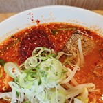 信長ラーメン - スープには赤い香辛料がたくさん振りかけてあります。（2024.5 byジプシーくん）