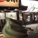 丸源ラーメン - 看板を撮影しながらテイクアウトソフトクリーム