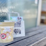 働希舎かもみーる - スノーボール　
背後のショップバッグは地元の新聞を再利用したもの。マチ付きで、把手も握りやすい優れもの。