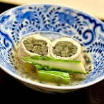 道人 - ⑧青干し薇 〜竈で松葉を燃やしゼンマイを蒸して燻製にしたものを油揚げで巻いた信田巻きは見た目のインパクト抜群。燻製することで青干しゼンマイはさらに独特の風味と香りを持ち料理に深みをもたらす。茹でたゼンマイは赤干しゼンマイと呼ばれるらしい。