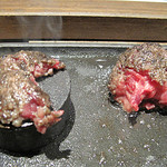 まるたんや - 伊万里牛ステーキつくね。
            ハンバーグ状に丸めたナマ牛挽肉を小さな円柱状の鉄板で焼いて頂きます。
            