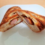 ブーランジュリー パリゴ - 表面はパリッと薄くチーズが香ばしい！ジューシーなソーセージと粒マスタード、風味豊かな生地の一体感抜群