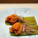 すし宮川 - ウニ。 煮浸して薄くスライスした茄子の上にムラサキウニと茗荷。 茄子をくるんと巻いて丸ごといただきます。 トロトロに濃厚で海の旨味の王者が、油が染み込んだ甘い茄子に包まれて、 口の中はゴージャスな宮殿のようになります。 酒が知らぬ間に消えていきます。