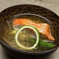 徳ㇵ本也 - ❸椀物
                      〜鰹節が効いたちょっと味わいが増した出汁は、"THE 和久傳"の香りが嬉しい。旬の賀茂茄子と朱色が鮮やかな金目鯛も、この出汁の味わいがあってこその旨味を感じさせる。三つ葉と柚木は香り付け。