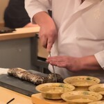 登喜和鮨 -  梭子魚禰宜巻炭焼きを切る