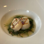 サバティーニ・ディ・フィレンツェ - 魚料理（帆立貝のグリル 魚介を凝縮した乳白色のスープ仕立て スペルト小麦とオカヒジキと共に爽やかなハーブオイルと穂紫蘇のアクセント）