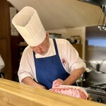 洋食 おがた - サドルバック豚をカットする緒方シェフ。オーラ満載