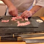 すしやのたい悟 - 中落ちを皮際から掻き取っているところ。