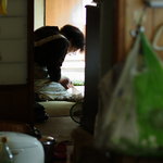 八幡屋 - 客に氣附かず新聞ちらしを弄（まさぐ）る