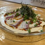 焼きもの家 慶 - ゴマかんぱち。固めにキリッとしたカンパチをゴマとラー油がキリッと引き立てて、敷いてある長ネギが別のベクトルの味と食感を添える。