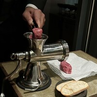 VinIX - 席にてミートミンサーで肉塊をミンチ状にします