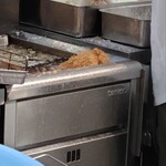 とんかつ目黒こがね - 先の方だけ油につけています。余分な脂肪を落としているのでしょうか