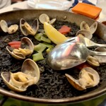 カラ カルメン - 真っ黒なパエリヤ、上に乗るのは大粒のアサリ、彩りに赤パプリカにサヤインゲン、レモン。