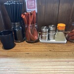 貝ガラ屋 - 卓上。一味、ブラックペッパー、レモン汁、その他自家製ラー油がある。