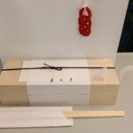 鮨 三心 - お土産の紙袋、水引のアクセサリーが可愛い
      木箱に南関揚げの稲荷寿司が入っています