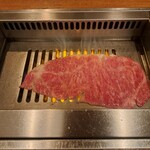 焼肉うしごろ - 網の鉄板の上で焼いている、鹿児島県産の大判サーロインその1です。