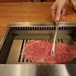 焼肉うしごろ - 網の鉄板で焼いている、鹿児島県産の大判サーロインその4です。