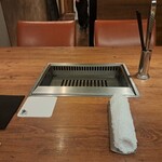 焼肉うしごろ - 私がついたテーブル席と、網の鉄板です。