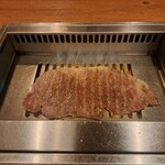 焼肉うしごろ - 網の鉄板の上で焼いている、鹿児島県産の大判サーロインその2です。