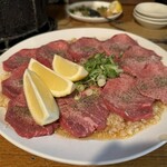 万正 - にんにくと薬味が敷かれた厚切り塩たん