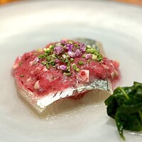馳走西健一 - ❷泳がせ真鯵
                    〜鮮度抜群の泳がせ真鯵は、ビジュアルも美しい。庶民的な鯵を刻んだ枝豆、ビーツ、レッドオニオンに山椒醤油でマリネした豆鯵のコンソメスープをかけたもの。独特な味わいのモロヘイヤのお浸し添え。