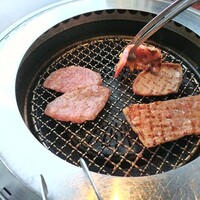 叙々苑 有楽町マリオン店 - 肉焼き中　お友達が肉つかみ中