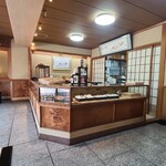 御菓子司 鶴屋 - 店内は木板張り天井、淡い黄土色の土壁、御影石の床、木製のショーケースがあり和菓子屋さんらしい雰囲気、BGMはありません
お席はテーブル2席×1卓のみ