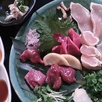 鰻割烹 心艶 - 向こうに付き出し、鶏さしみ盛り合わせ（右上からモモたたき、笹身タタキ、砂肝、レモンの下にレバー、ハツ、左上・白レバー）