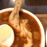 スープカレー屋 鴻 神田駿河台店 - オードリーのスープカレー【赤】チキン骨付き、ルーのアップ。具が大きい。