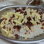 かれーの店 うどん  - トッピングのスパイシーひき肉とチーズはライスの上に乗って提供される。これが「フリカケ」の役割。(ご飯の上にフリカケが掛かった状態)。