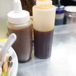 中華そば みたか - 左が特製ニンニク 右がラー油 昭和の大衆食堂では普通に有った調味料入れ 今はあまり見なくなった 左の特製ニンニクが入ったボトルは我が家にも有ってはちみつ入れだった記憶が有る