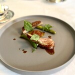 マダム・トキ - ミルクのみしか口にしていない仔羊のコンフィ。柔らかくてクセのない美味しさ。付け合わせにグリーンアスパラ、万願寺唐辛子、香りの良いセルバチコ。