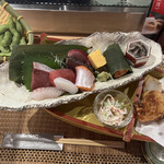 新潟・佐渡島 両津港直送 土風炉 - 豪快船盛会食２５００円。お造りは鰤、鯛、鮪、イカ、サーモン、鰹です。鮮度も良かったです。笹に巻かれた村上鮭の焼き物にナマコ、脇にはカニカマサラダ、鶏の唐揚げ、枝豆です。