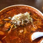焼肉・冷麺 三千里 - 真っ赤な旨辛スープにたっぷりの野菜！ネギとゴマが乗ってます。