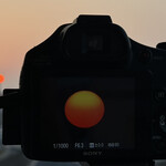 そば処 砂武縞 - 日の出の方位は急速に南下を続けていてついに東大通りの向こうの第一日の出ビルの右に達した。秋の観空シーズン開幕。秋分も近い。今朝は重いモヤと少しの霧が重なった天然フィルターのお陰で太陽黒点もよく見えた