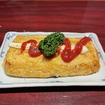 快食倶楽部 万年 - 出汁巻きみたいなオムライス。中はトロトロ。バターの風味がかなり効いてる。ケチャップの上から振りかけた擦りごまも、食欲そそるアクセントに。