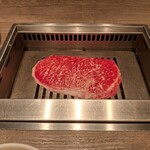 焼肉うしごろ - 網の鉄板の上で焼いている、群馬県産の大判サーロインその1です。