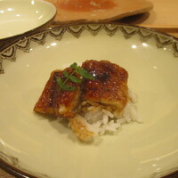 奥 - 青鰻：三河一色産 一年物の青鰻を甘辛く、芳ばしく、ふっくらと焼きたてで岐阜 “はつしも“（白飯）と一緒にいただきます。上には木の芽が添えられています。