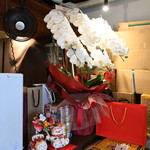 NIBOSHI MANIA - カウンター隅の胡蝶蘭とお祝いの品（少し消費されたみたい）