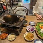 タレ焼肉と包み野菜の専門店 焼肉くるとん - 脂が飛ぶのでエプロンします