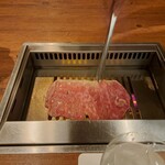 焼肉うしごろ - 群馬県産の大判サーロインを、網の鉄板で焼いている様子のその2です。