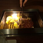 焼肉うしごろ - 群馬県産の大判サーロインを、網の鉄板で焼いている様子のその6です。ファイアーダンスが絶好調ですね。