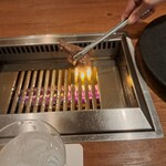 焼肉うしごろ - 群馬県産の大判サーロインを、網の鉄板で焼いている様子のその3です。