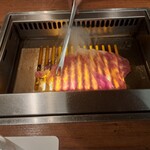 焼肉うしごろ - 群馬県産の大判サーロインを、網の鉄板で焼いている様子のその5です。