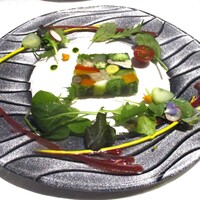 四間道レストランMATSUURA - “スペシャリテ” 農園野菜のテリーヌ：夏をイメージした農園野菜のテリーヌには赤andオレンジのパプリカ、人参、ゴボウ、ヤングコーン、椎茸 etc．18種の野菜が彩りよく使われ、その周りには、ルッコラ、プチトマト、アディッシュ、ズイキ、ベビーリーフと共に ビーツ（赤）、サフラン（黄）、バジル（緑）、人参（オレンジ）のソースが美しくあしらわれています。