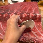 木場場外市場 まぐろ祭 - 貝殻使って、そぎ落としながら食べます。