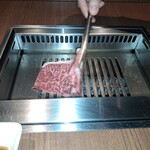 焼肉うしごろ - 鹿児島県産の大判サーロインを、網の鉄板で焼く様子のその1です。
