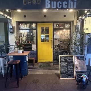 黄色い扉が目印のお店。2階にはテーブル席もございます。