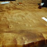 とんかつ 新 - 一枚の板で作られた重厚な木製のテーブル。